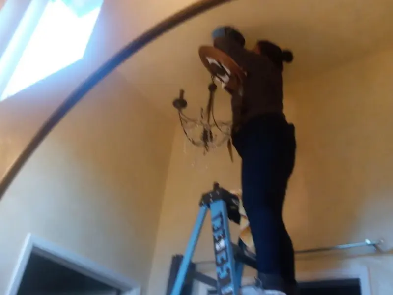 Electrician installing a chandelier in a Capitol Heights residence